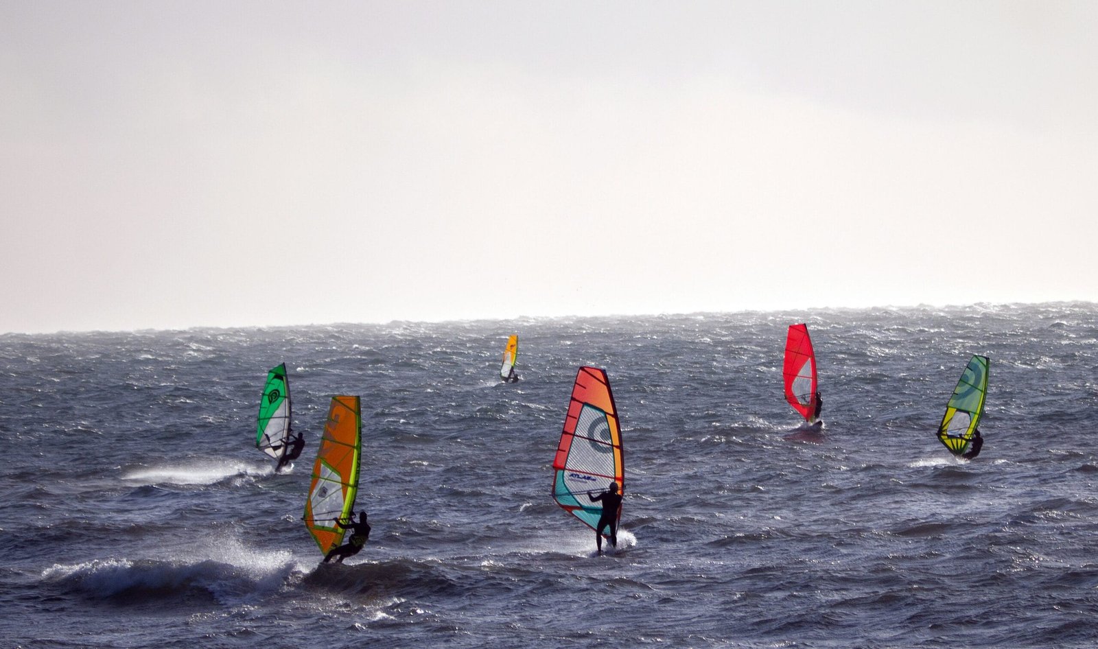 a group of people wind surfing in the ocean